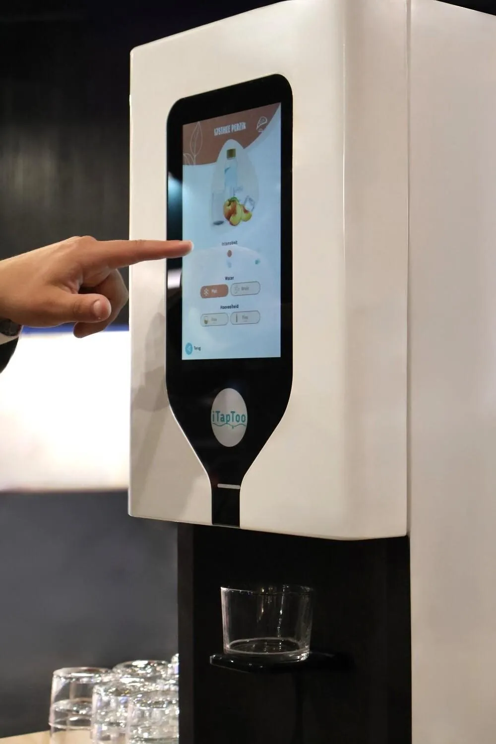 Iemand bedient het touchscreen van een iTapToo-watertap